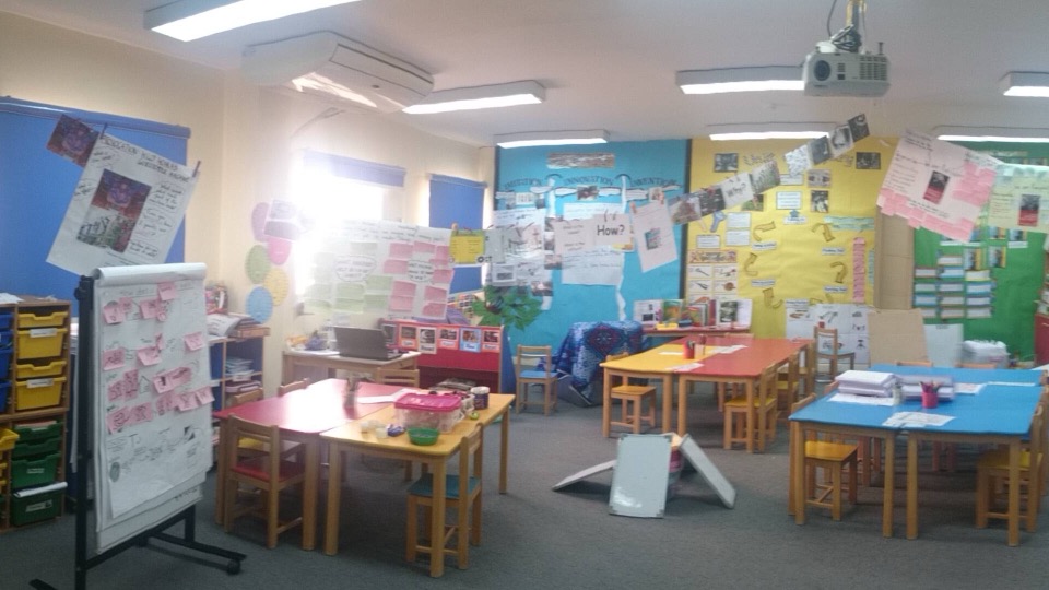 A wide view of a classroom with tables and resource trays